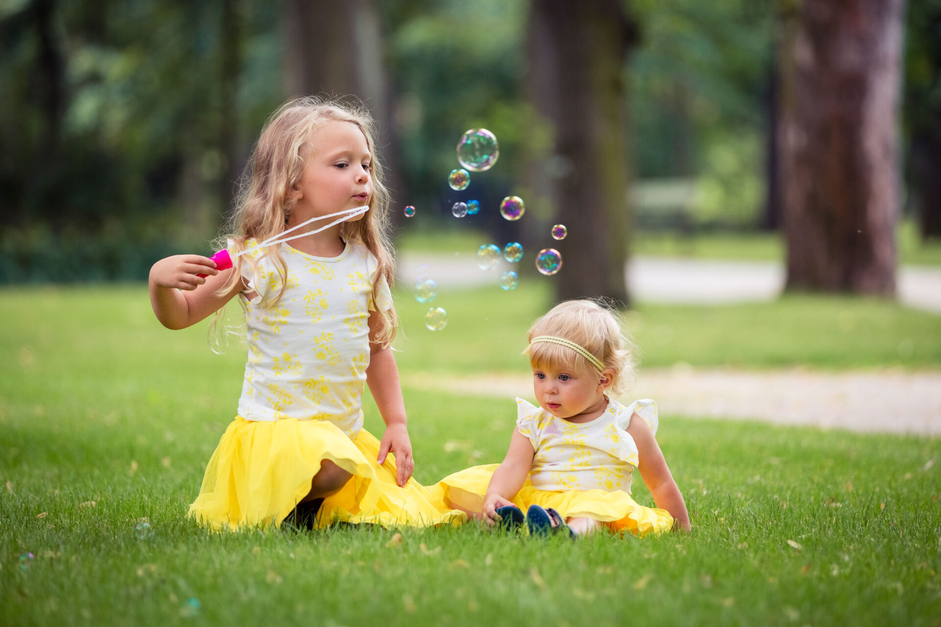 Perhekuva otettu puistossa. Vanhemmat ja lapsi kuvassa. Perhekuvaus Jyväskylässä.