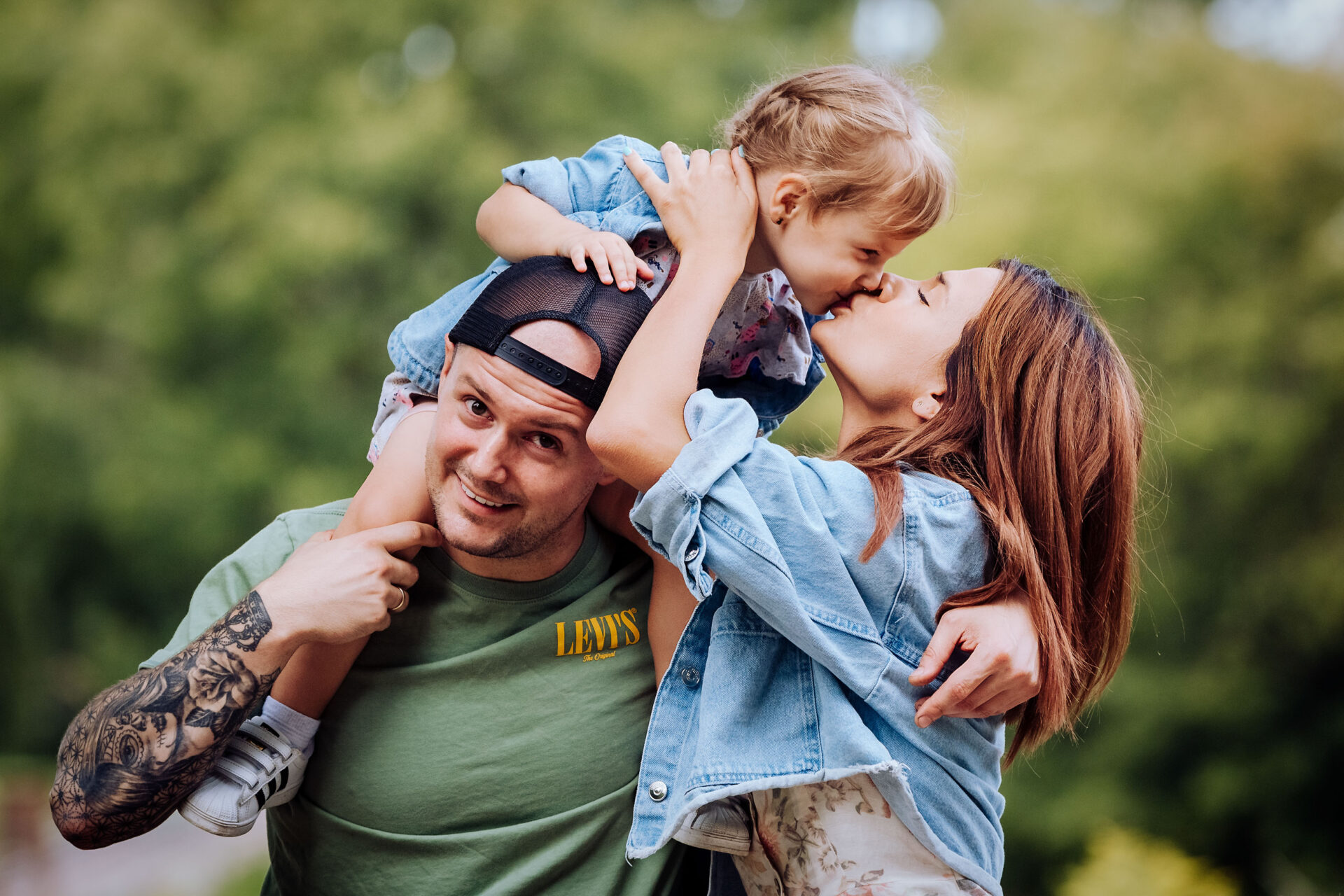 Perhekuva otettu puistossa. Vanhemmat ja lapsi kuvassa. Perhekuvaus Jyväskylässä.